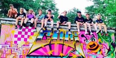 Jugendliche sitzen auf einer, mit Graffiti besprühten, Wand