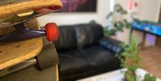 übereinander gestappelte Skateboards stehen vor einem Sofa