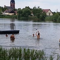 Junge Menschen baden und spielen im See