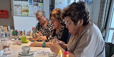Dre ältere Frauen basteln gemeinsam