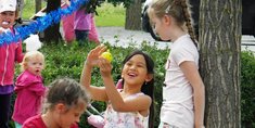Kinder unterschiedlichen Alters spielen mit einem kleinen gelben Ball