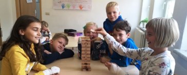 Kinder bauen einen Turm aus Holzsteinen