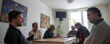 Sechs Männer am Tisch im Aufenthaltsraum des Haus Strohhalm