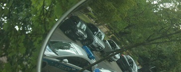 Polizeiwagen im Seitenspiegel eines Autos